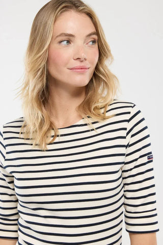 Woman wearing a navy and white striped Breton shirt with elbow-length sleeves
