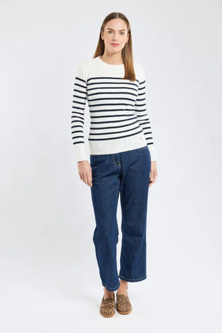 Woman wearing a navy striped white sweater with blue jeans and leopard print flats