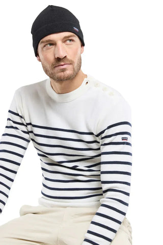 Man in a black knit beanie and white striped sailor sweater with button shoulder detail
