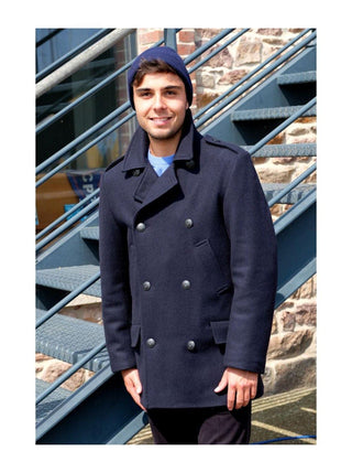 Man wearing a navy wool double-breasted pea coat standing outdoors by stairs