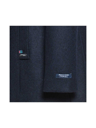 Close-up of navy wool coat fabric with Maison à Kabic label, women's outerwear detail