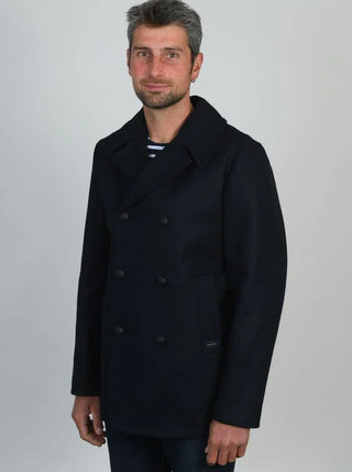 Man wearing a navy wool pea coat with double-breasted buttons and wide collar