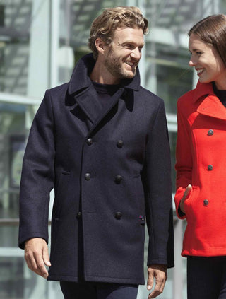 Man wearing navy wool pea coat, double-breasted style, smiling outdoors