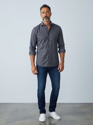 Homme portant une chemise charcoal Emanuel Berg Byron en maille extensible avec un jean bleu et des baskets blanches