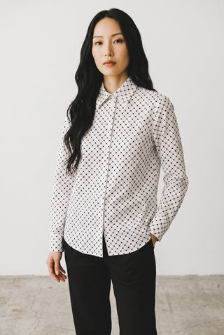 Blouse à carreaux Le Capitaine D'a Bord en coton blanc avec broderies délicates, portée par une femme aux cheveux longs.