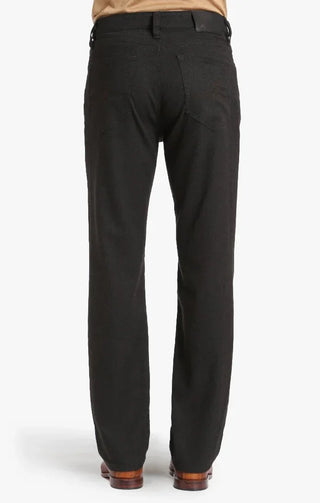 Back view of men's brown tweed straight-leg pants with belt and leather shoes