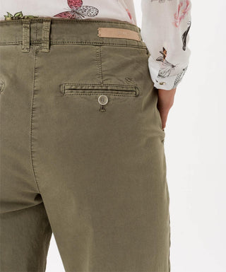 Close-up of olive green cotton pants with back pockets, paired with floral blouse