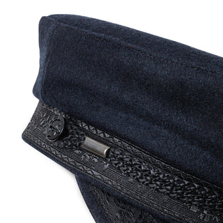 Close-up of a navy wool captain's hat with decorative braid and button detail