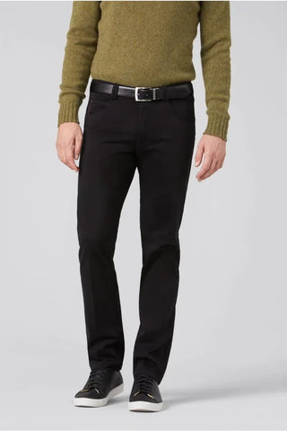 Man wearing black cotton pants and black sneakers with a green sweater