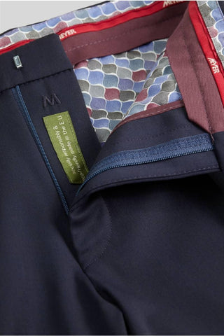 Close-up of navy wool pants with blue zipper and multicolor patterned waistband lining